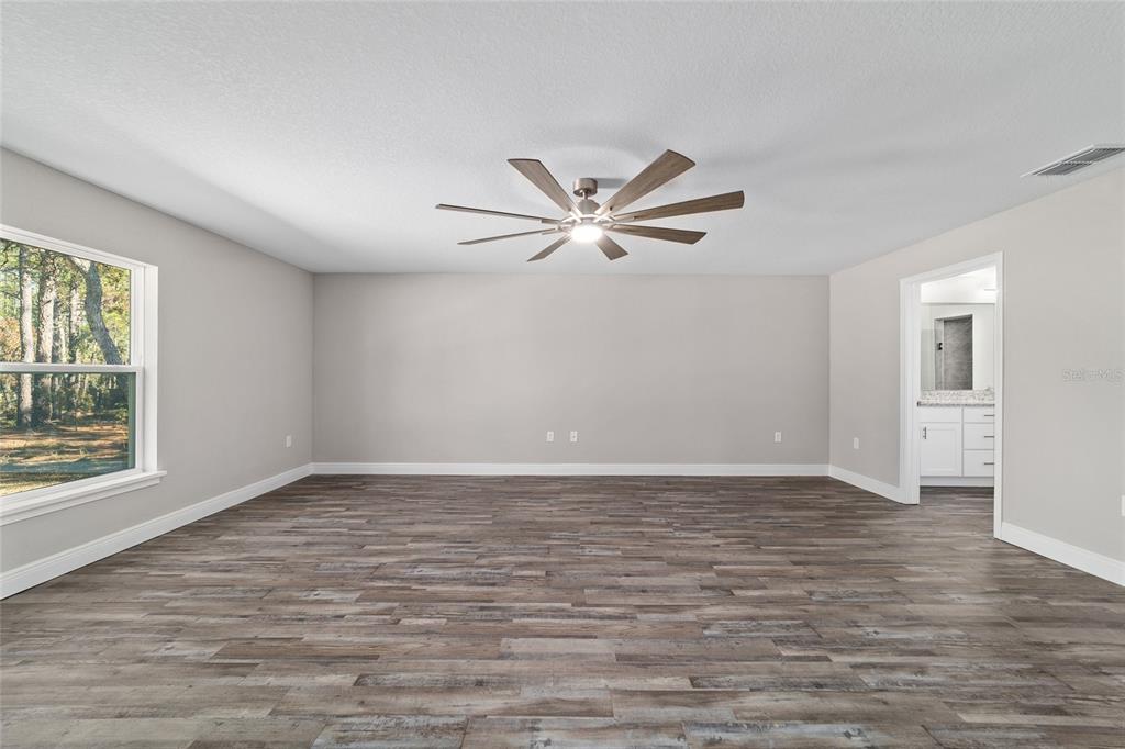 13359 Southwest 80th Street Dunnellon, FL 34432 - Photo 32 of 64 an empty room with wooden floor and windows
