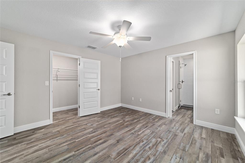 13359 Southwest 80th Street Dunnellon, FL 34432 - Photo 44 of 64 an empty room with wooden floor closet ceiling fan and windows