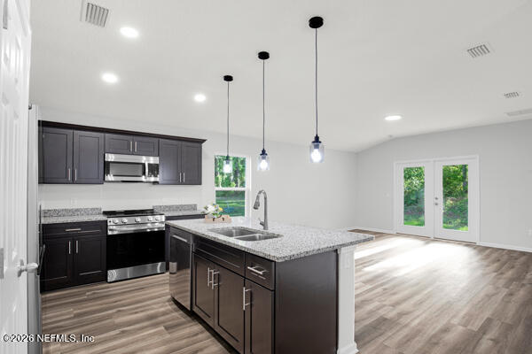 407 Rustic Road Satsuma, FL 32189 - Photo 14 of 55 a kitchen with stainless steel appliances granite countertop a sink a stove and a wooden floors