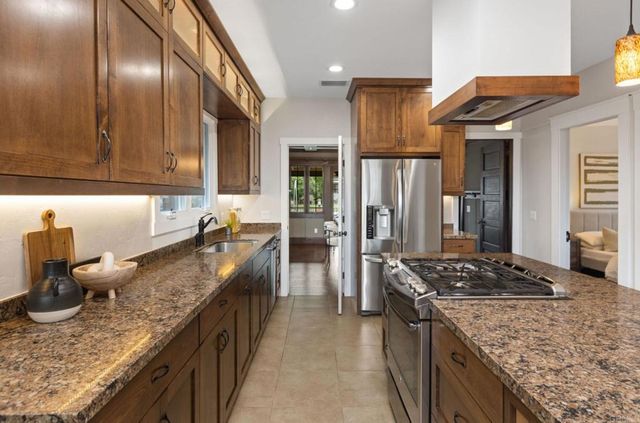 a kitchen with granite countertop stainless steel appliances and wooden cabinets