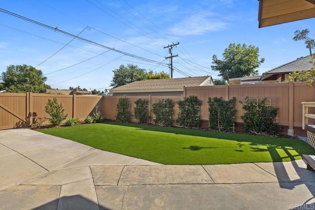 a view of a house with a yard and potted plants