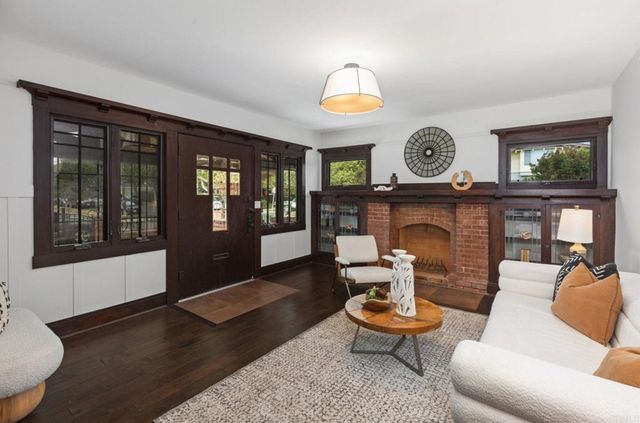 a living room with fireplace furniture and a large window