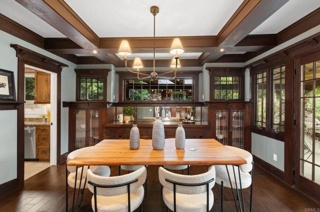 a dining room with furniture a chandelier and wooden floor