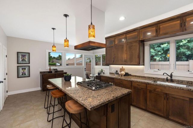 a kitchen with a table chairs stove and wooden floor
