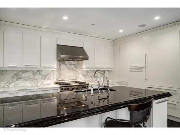 a kitchen with kitchen island a sink stove and cabinets