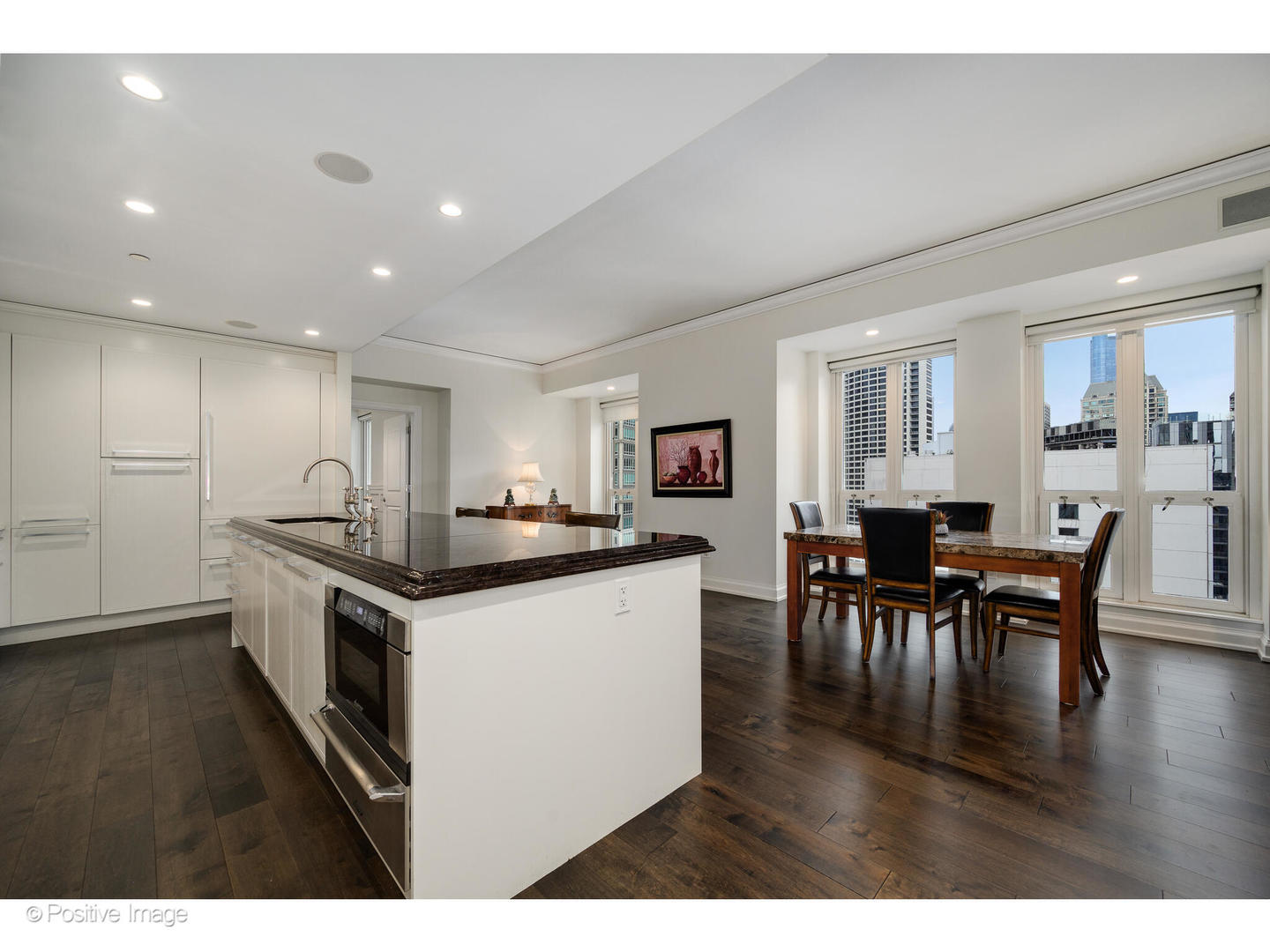 11 East Walton Street, Unit 3201 Chicago, IL 60611 - Photo 13 of 42 a kitchen with stainless steel appliances kitchen island granite countertop a stove top oven a sink a dining table and chairs