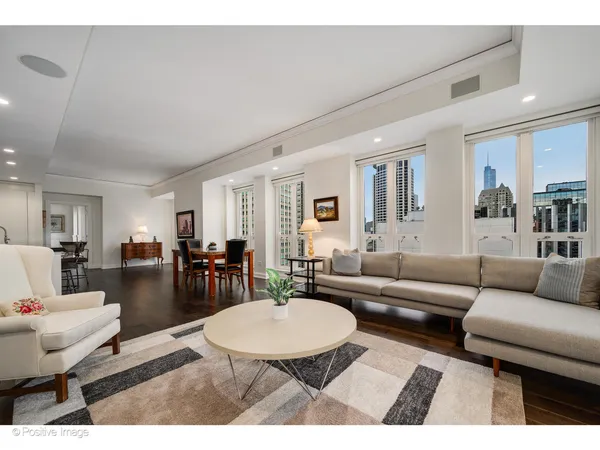 a living room with furniture a table and kitchen view