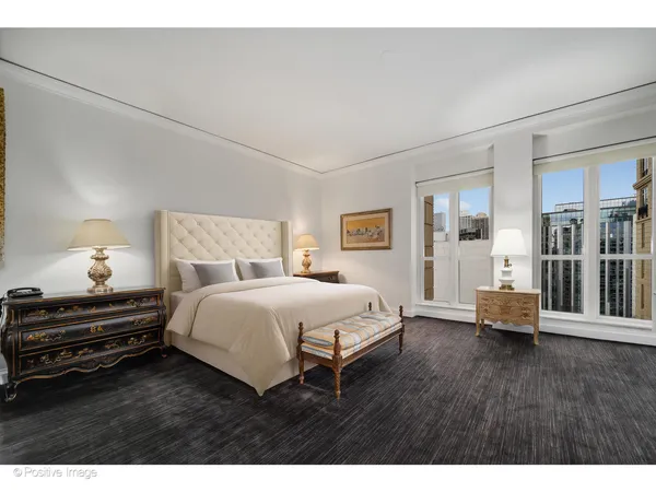 a spacious bedroom with a bed and wooden floor
