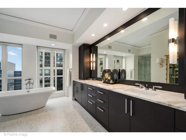 a bathroom with a bathtub sink double vanity