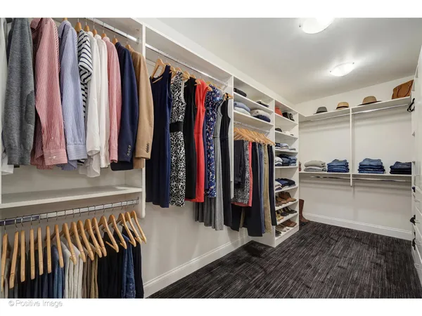 a view of walk in closet with clothes