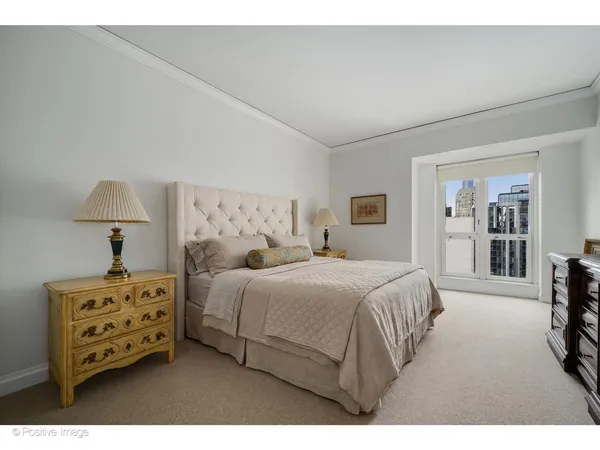 a bedroom with a bed a lamp and a large mirror