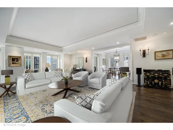 a living room with furniture a wooden floor and next to a window