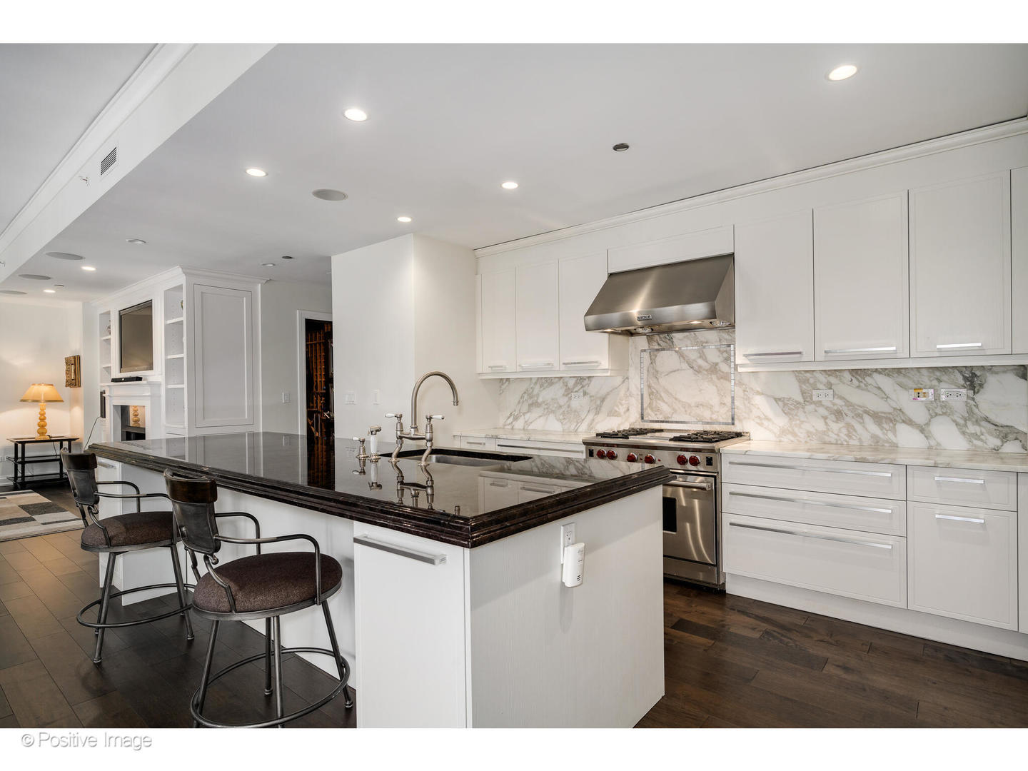 11 East Walton Street, Unit 3201 Chicago, IL 60611 - Photo 9 of 42 a kitchen with kitchen island granite countertop a sink and white cabinets