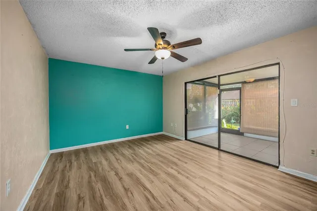 a view of a big room with wooden floor fan and windows