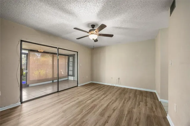 a view of empty room with ceiling fan and window