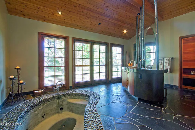 a spacious bathroom with a granite countertop tub sink and mirror