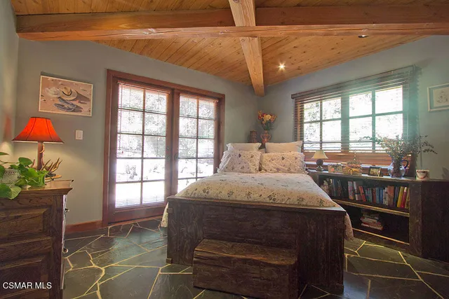 a bedroom with a bed a chandelier and a window