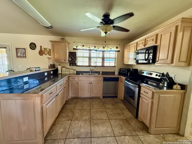 a kitchen with stainless steel appliances granite countertop a stove sink and cabinets