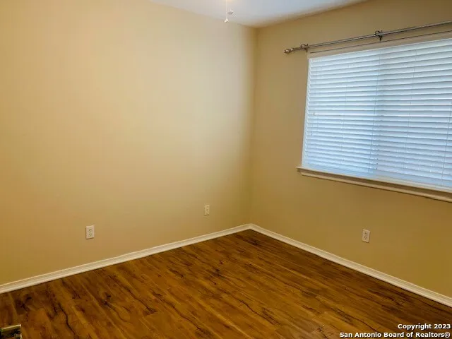a view of a room with wooden floor and a window