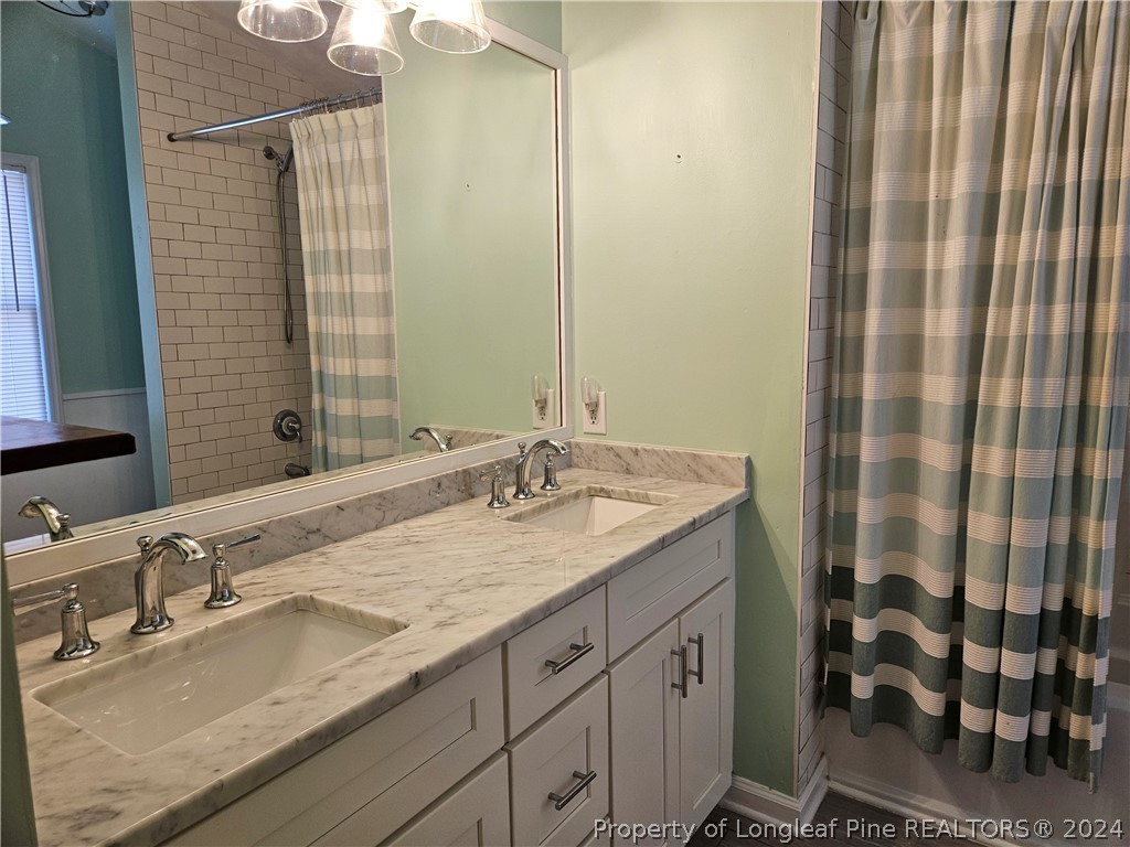 2825 Isabella Drive Raleigh, NC 27603 - Photo 21 of 31 a bathroom with a granite countertop sink and a mirror