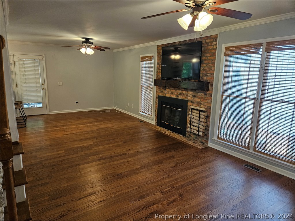 2825 Isabella Drive Raleigh, NC 27603 - Photo 4 of 31 a view of an empty room with wooden floor and a fireplace