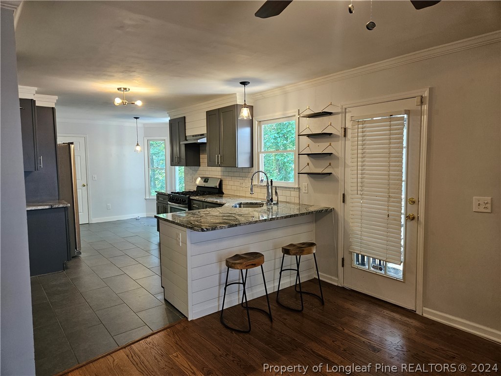 2825 Isabella Drive Raleigh, NC 27603 - Photo 6 of 31 a kitchen with kitchen island granite countertop a stove and a refrigerator