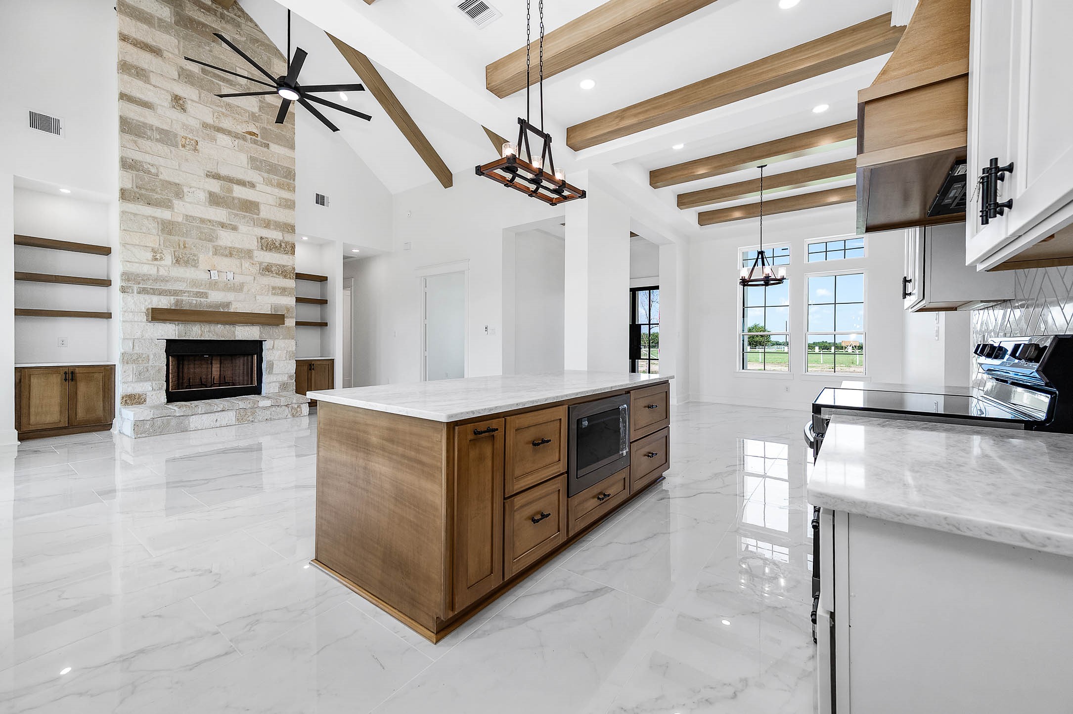 13911 Routt Point Road Needville, TX 77461 - Photo 8 of 19 Another angle of the open-concept space, highlighting the spacious living room, floor-to-ceiling stone fireplace, built-ins, and warm wood accents throughout.