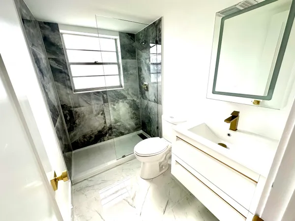 a bathroom with a sink toilet and shower