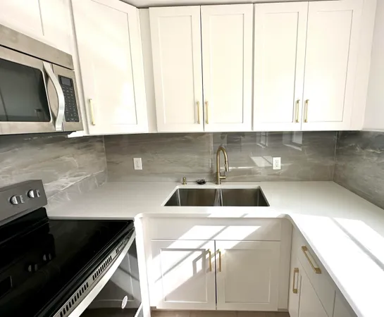 a kitchen with a sink a microwave and cabinets