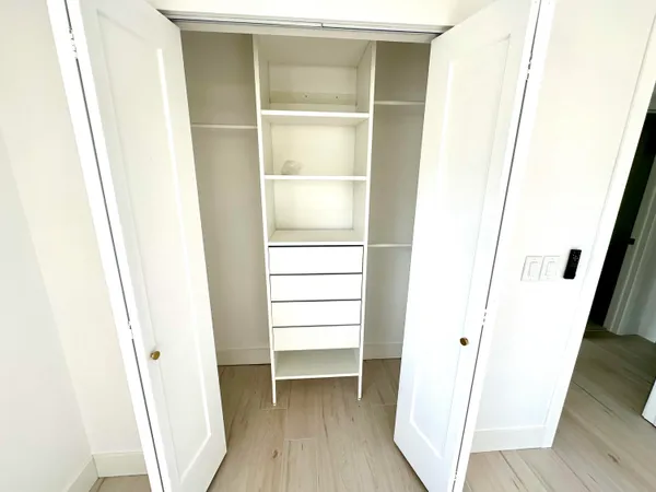 a view of closet area with wooden floor