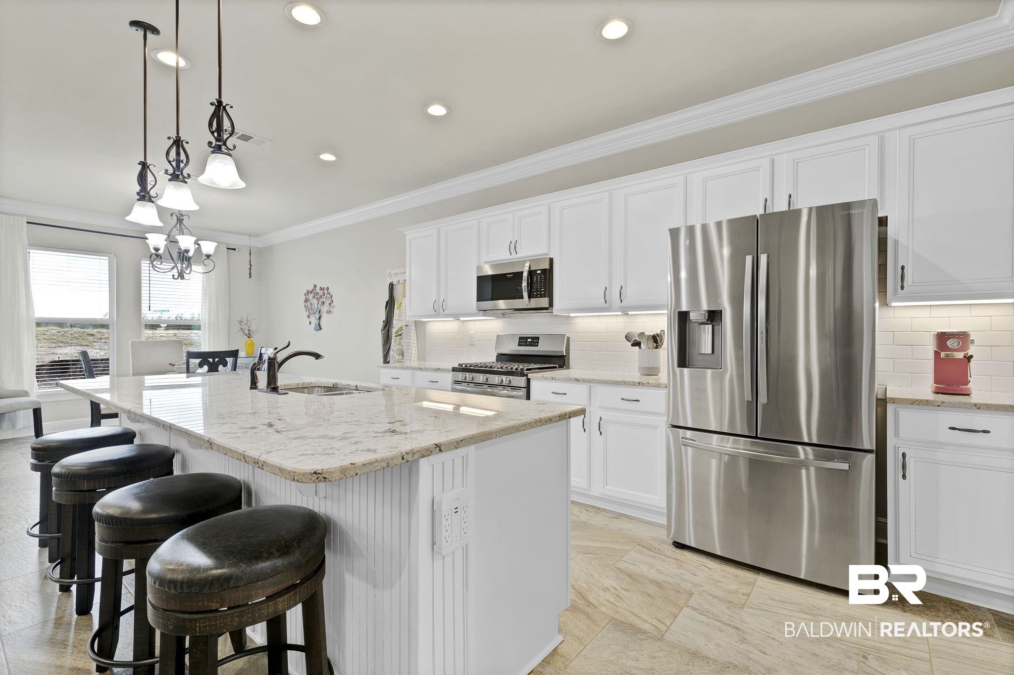 11247 Thistledown Loop Spanish Fort, AL 36527 - Photo 14 of 72 Kitchen with crown molding, stainless steel appliances, a kitchen island with sink, white cabinets, and a sink