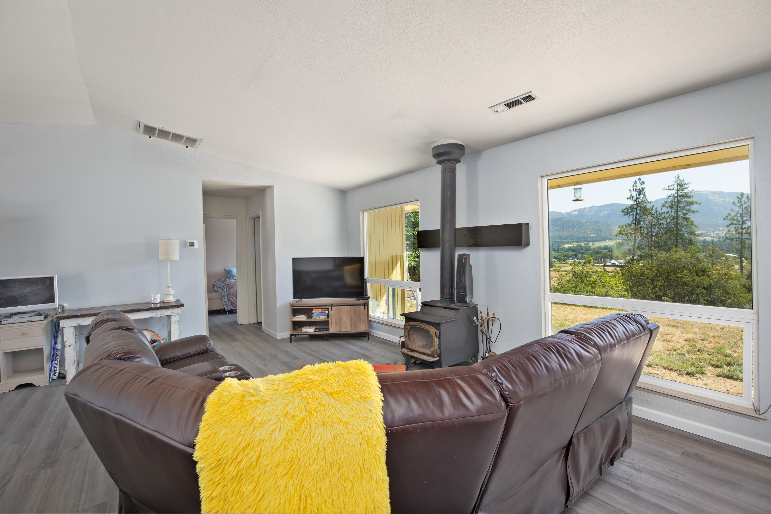 12748 Water Gap Road Williams, OR 97544 - Photo 10 of 35 a living room with furniture a fireplace and a floor to ceiling window