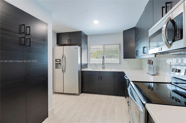 a kitchen with stainless steel appliances granite countertop a refrigerator and a sink
