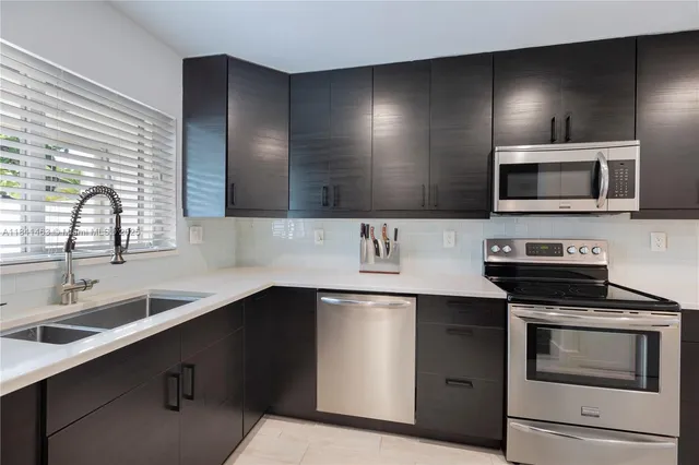 a kitchen with stainless steel appliances a sink stove and microwave