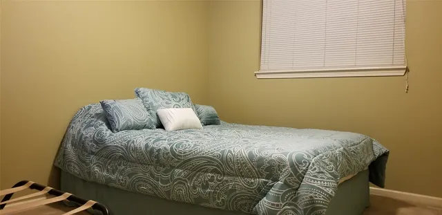 a bed sitting in a bedroom next to a window