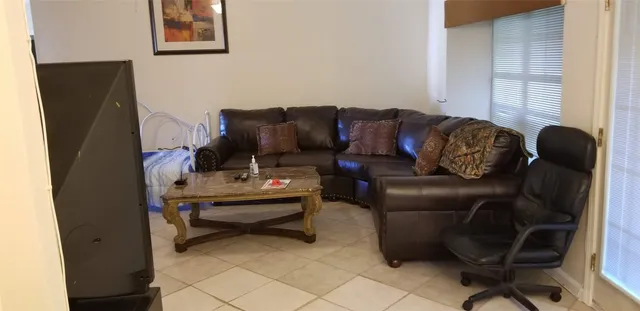 a living room with furniture and a piano