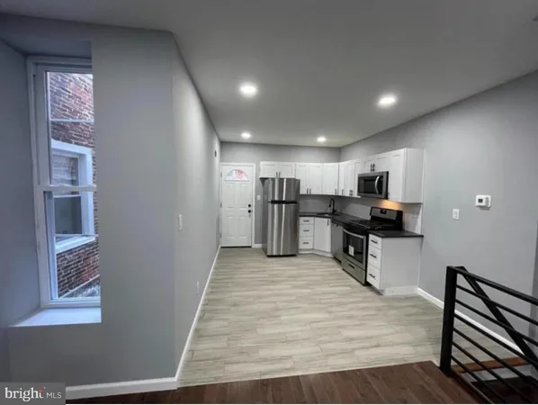 a large kitchen with kitchen island a sink stainless steel appliances and cabinets