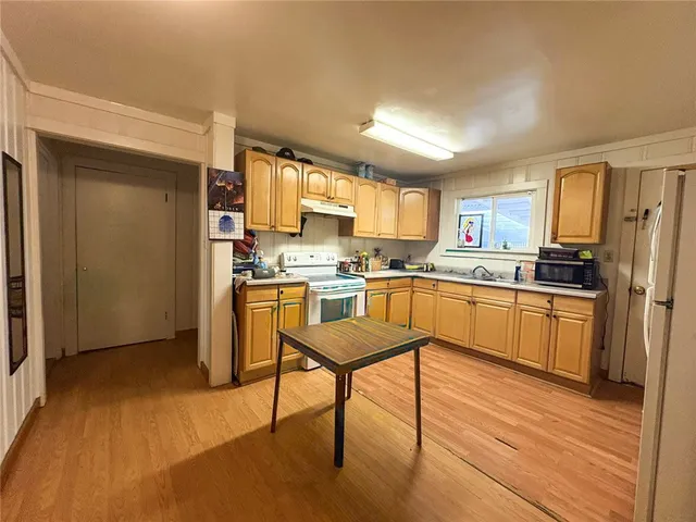 a kitchen with a refrigerator a counter top space and cabinets