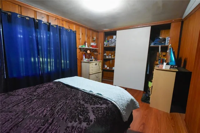 a bed sitting in a bedroom and closet with wooden floor