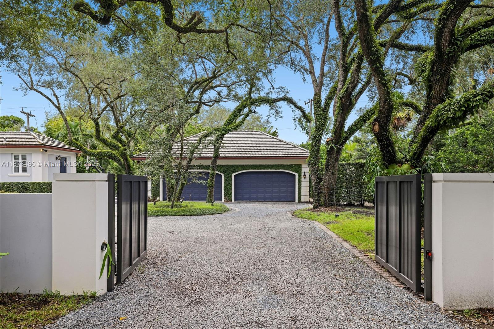 5400 Banyan Trail Coral Gables, FL 33156 - Photo 13 of 75 a front view of a house with garden and trees