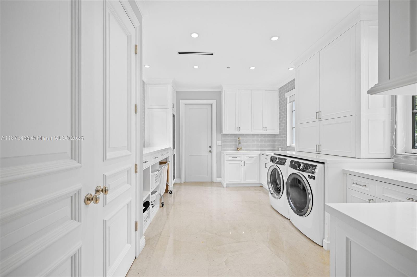 5400 Banyan Trail Coral Gables, FL 33156 - Photo 35 of 75 a view of a kitchen with white cabinets and washer dryer