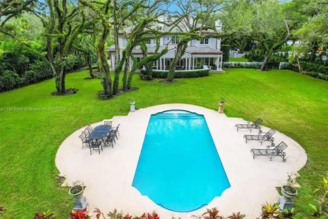 a view of a house with a big yard and large trees