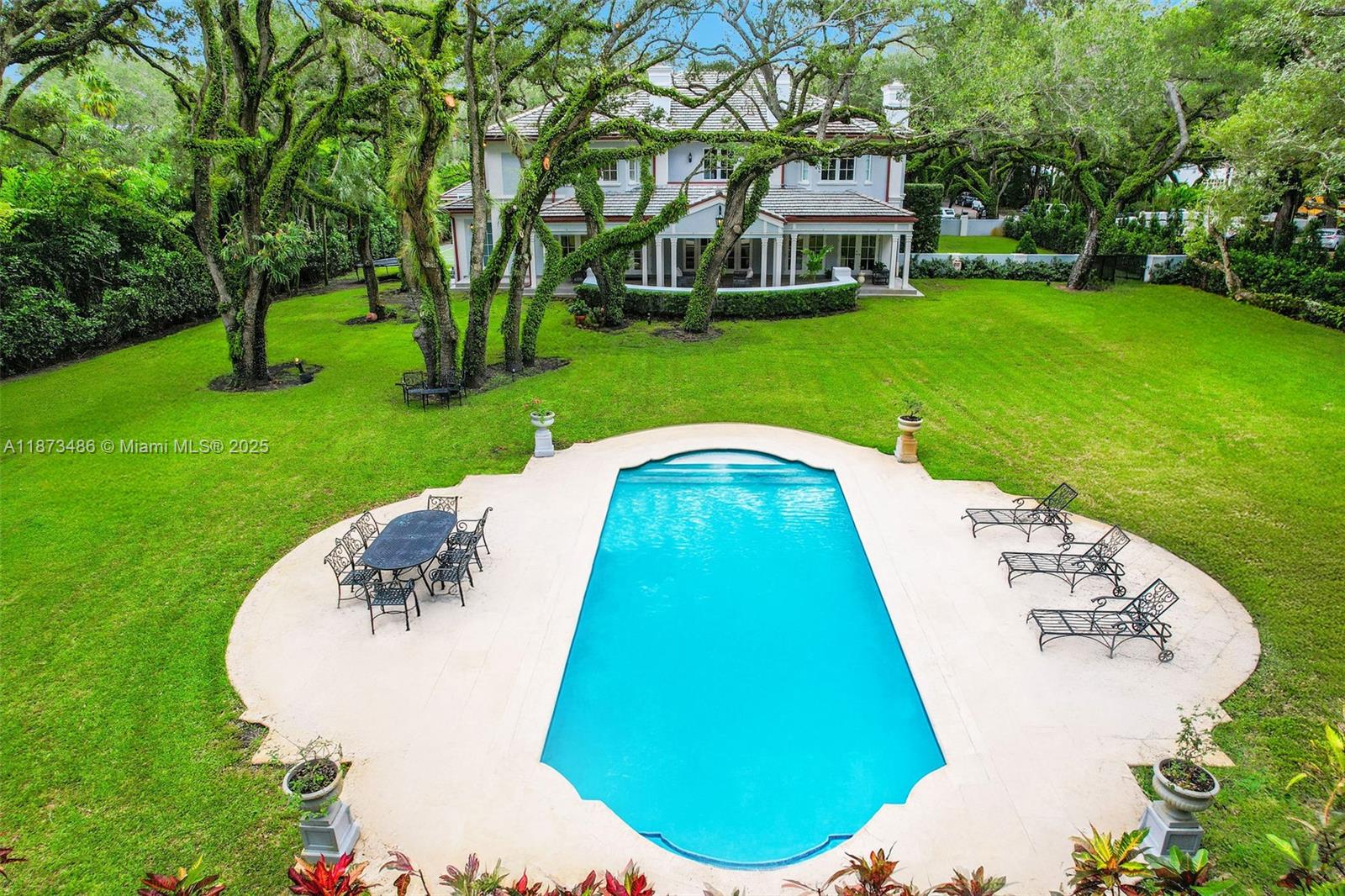 5400 Banyan Trail Coral Gables, FL 33156 - Photo 4 of 75 a view of a swimming pool with a garden and trees
