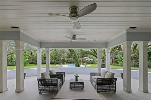 a view of a house with a yard and large trees