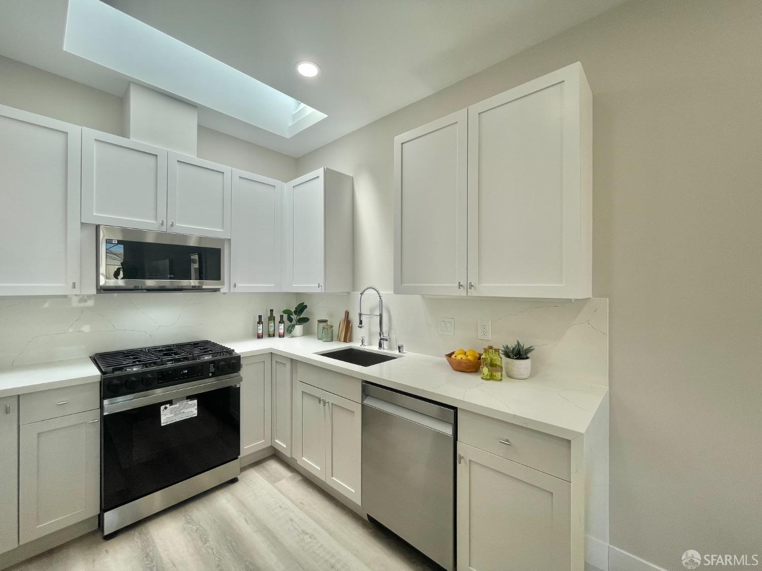 37 Ruth Street San Francisco, CA 94112 - Photo 9 of 26 a kitchen with stainless steel appliances a sink stove and white cabinets