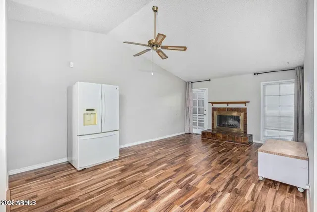 an empty room with windows and fireplace