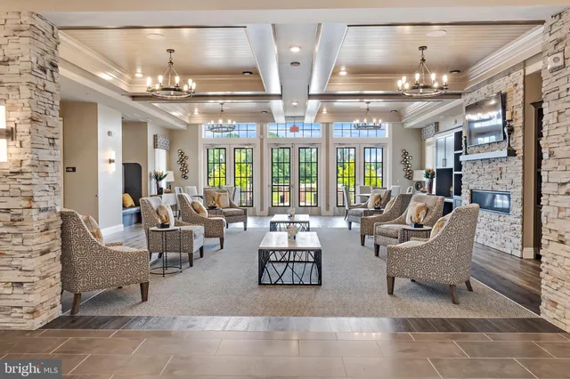 a view of a living room and kitchen with furniture wooden floor and windows