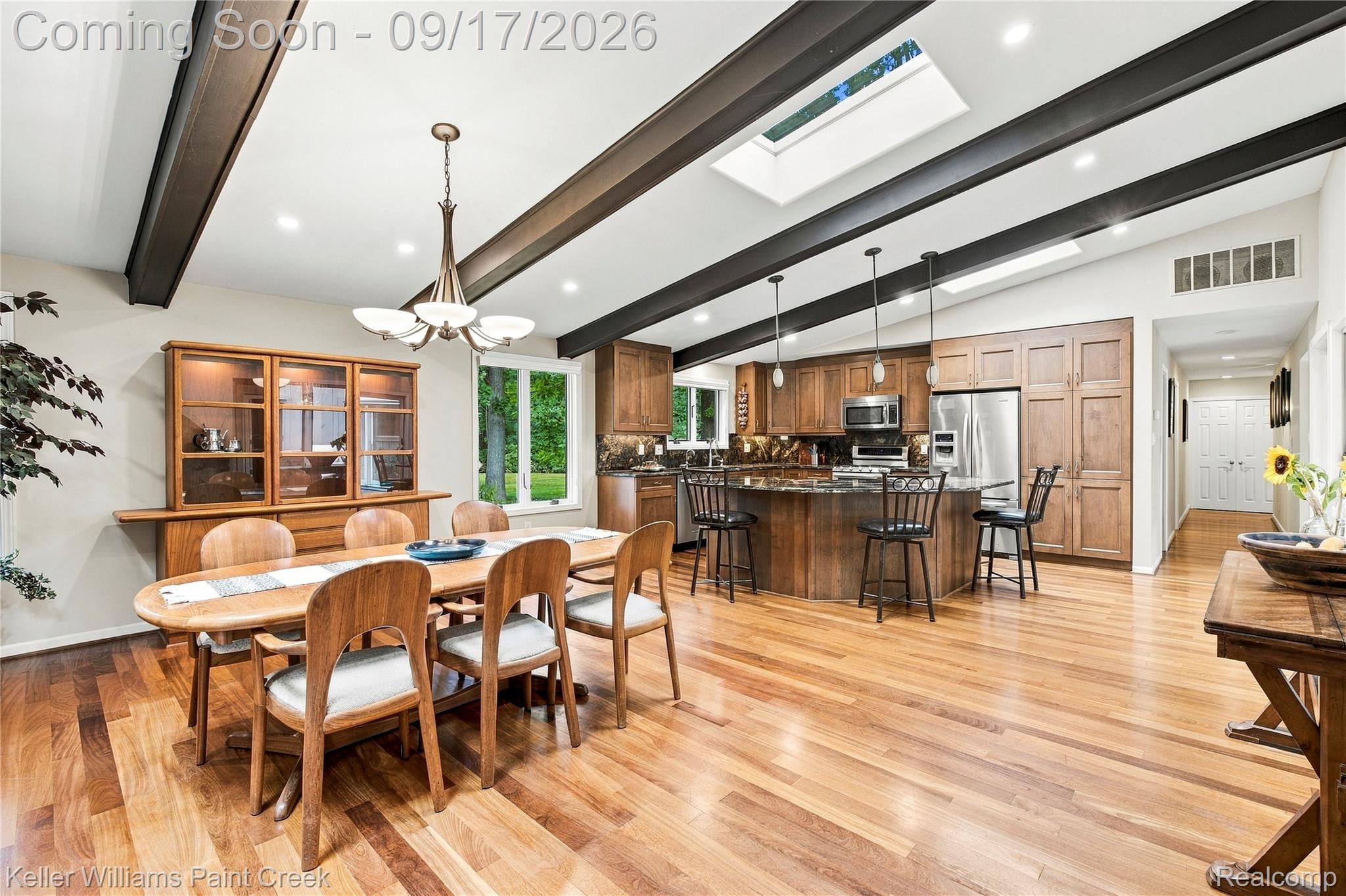 4535 Orion Road Rochester, MI 48306 - Photo 20 of 67 Vaulted ceiling with exposed beams and skylights, wood-finish flooring, wood cabinetry, stainless steel appliances, and a built-in kitchen island with seating