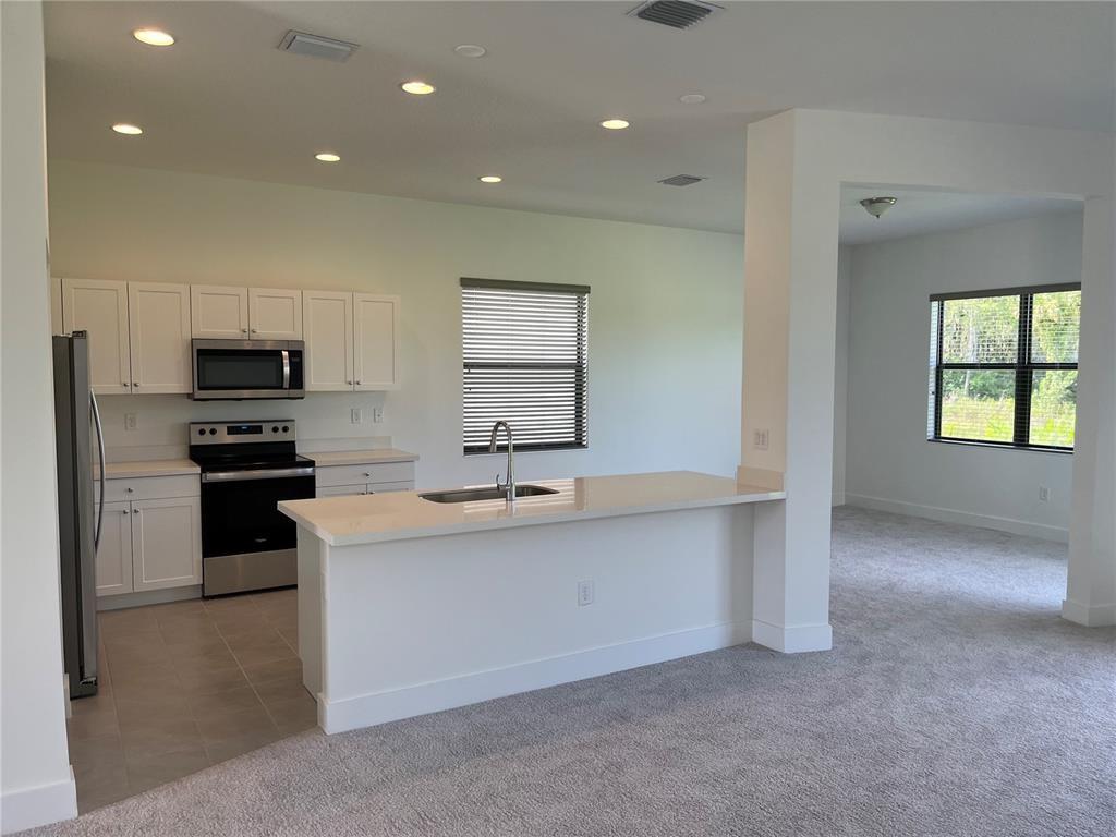 Undisclosed Address Immokalee, FL 34142 - Photo 6 of 30 a kitchen with stainless steel appliances a sink stove and cabinets