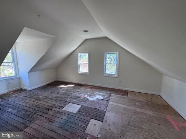 a view of a big room with wooden floor and windows